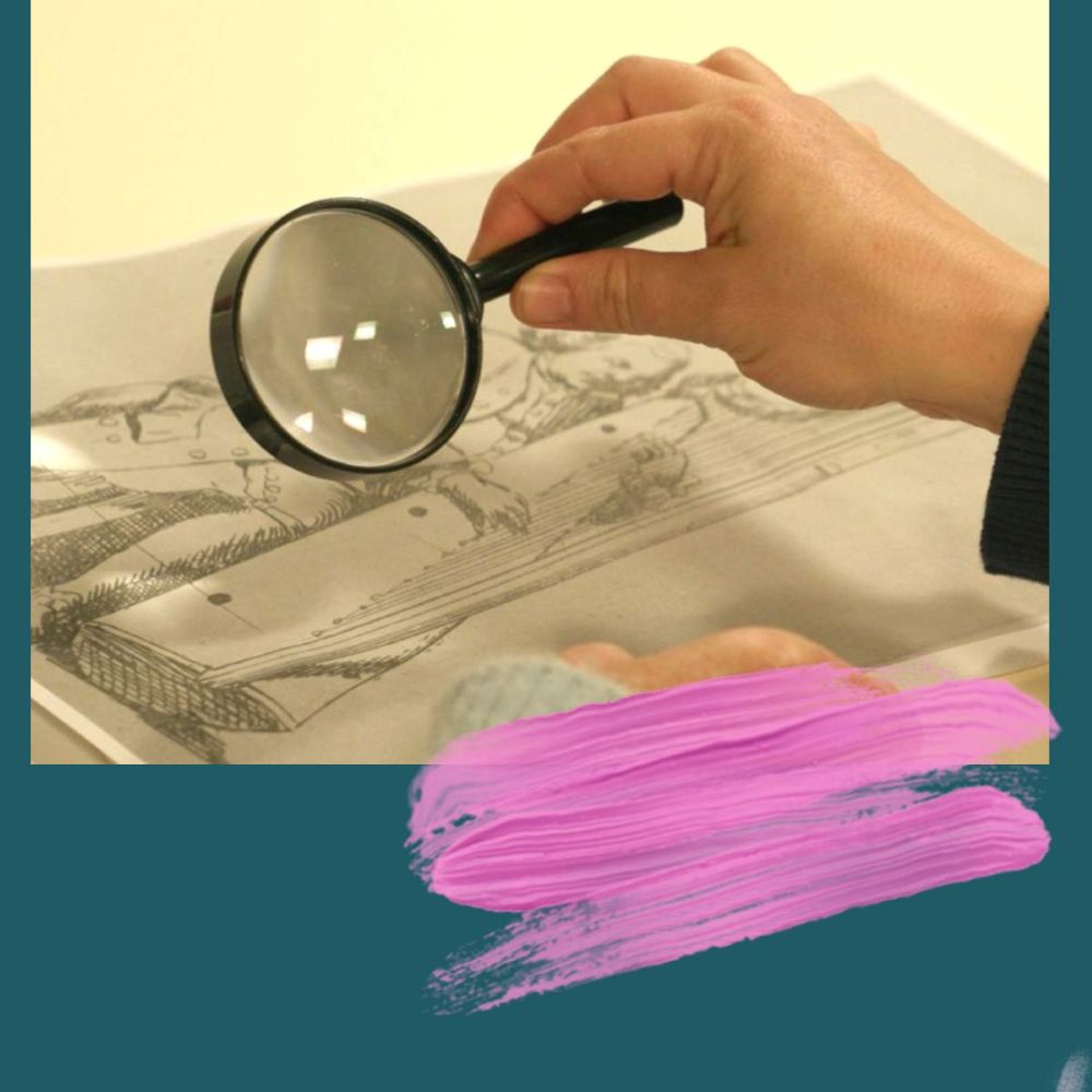 A hand holding up a magnifying glass to a black and white print laid on a table.